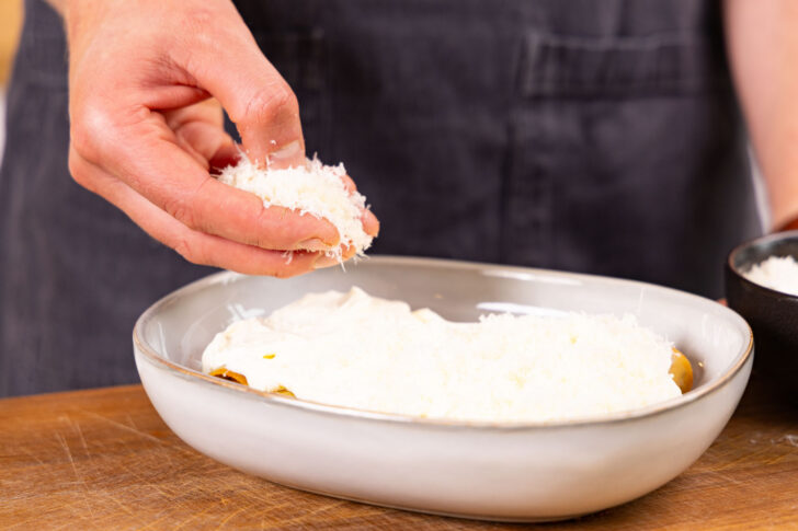 Cannelloni mit Parmesan bestreuen.