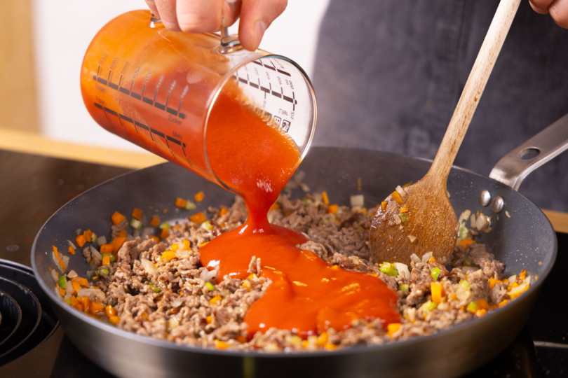 Passierte Tomaten zu Hackfleisch dazugeben.