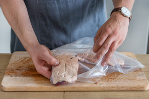 Geflügel in Vakuumbeutel geben