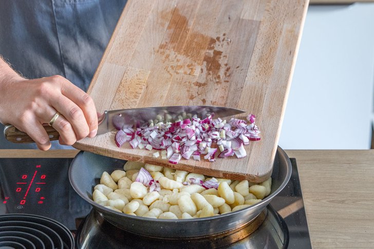 Zwiebel zu den Gnocchis geben