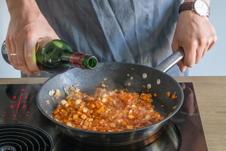 Gemüse für Hirschragout mit Rotwein ablöschen