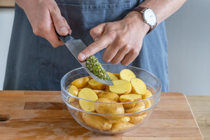 Rosmarin zu den Kartoffeln geben