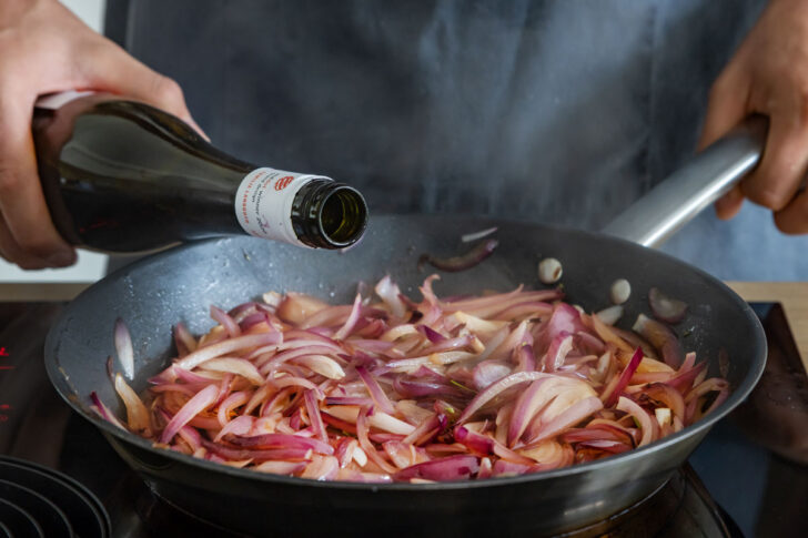 Wein zu den Zwiebeln gießen