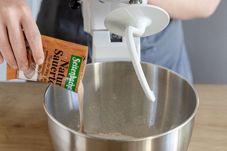 Sauerteig Ansatz zum Mehl geben