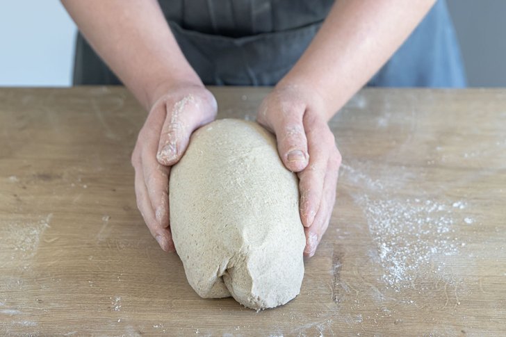 Roggenbrot mit Sauerteig zu einem Brotlaib formen