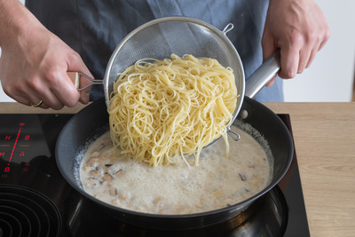 Spaghetti mit der Sauce vermengen