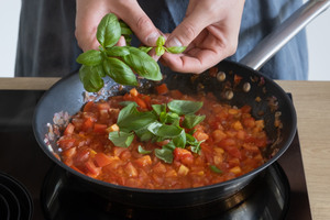Basilikum zur Tomatensauce für Piccata Milanese geben