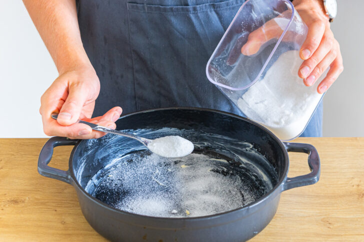 Auflaufform mit Butter einstreichen und Zucker darin verteilen