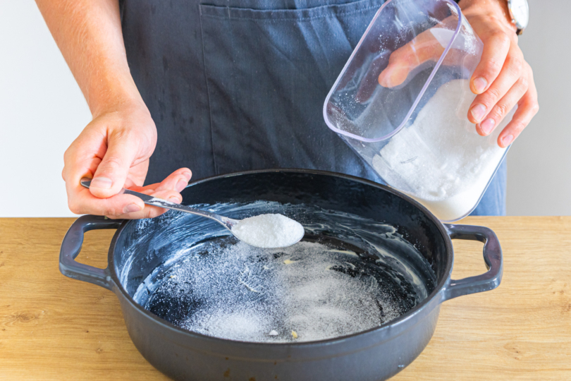 Auflaufform mit Butter einstreichen und Zucker darin verteilen