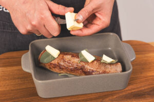 Butter auf die Salbeiblätter zum Kalbsfilet geben