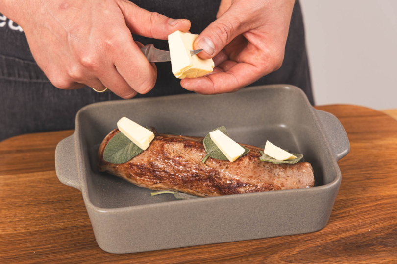 Butter auf die Salbeiblätter zum Kalbsfilet geben