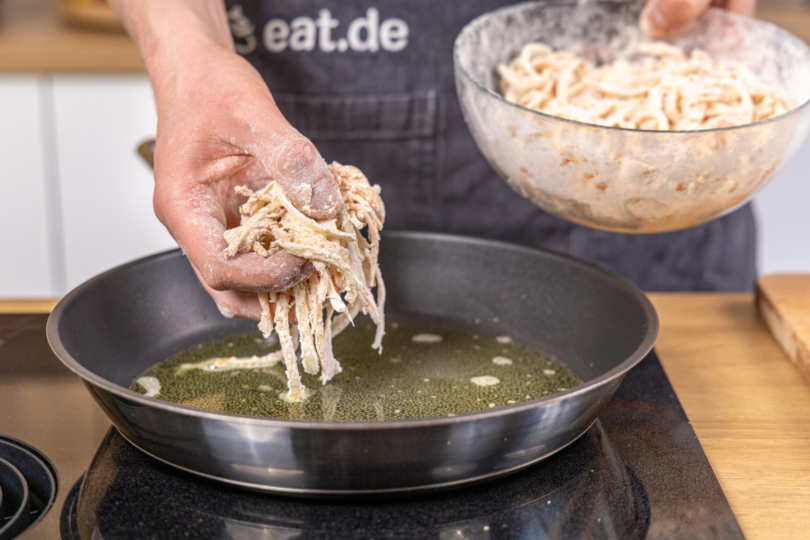 mehlierte Zwiebeln in die Pfanne geben