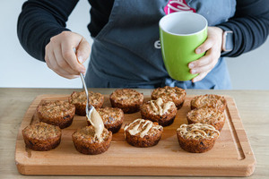 Ausgekühlten Hafermuffins mit leicht flüssiger Nussbutter verzieren