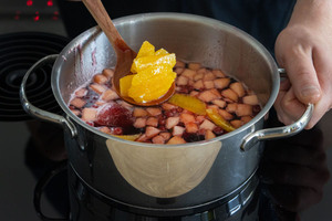 Orangenfilets zum Glühwein geben