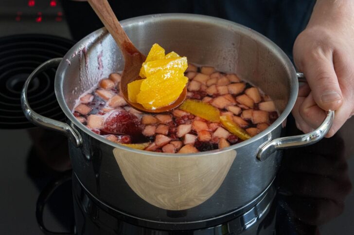 Orangenfilets zum Glühwein geben