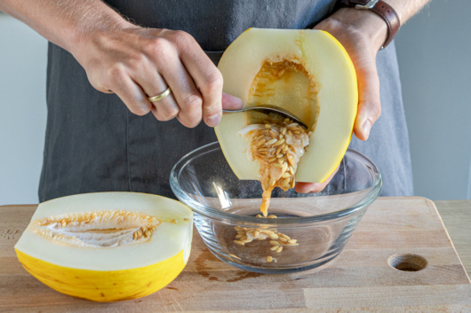 Kerne aus der Honigmelone herauskratzen