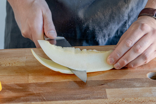 Schale von der Honigmelone abschneiden