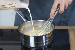 Milch in den Topf gießen
