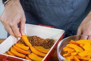 Die Kürbislasagne mit Hackfleisch schichten