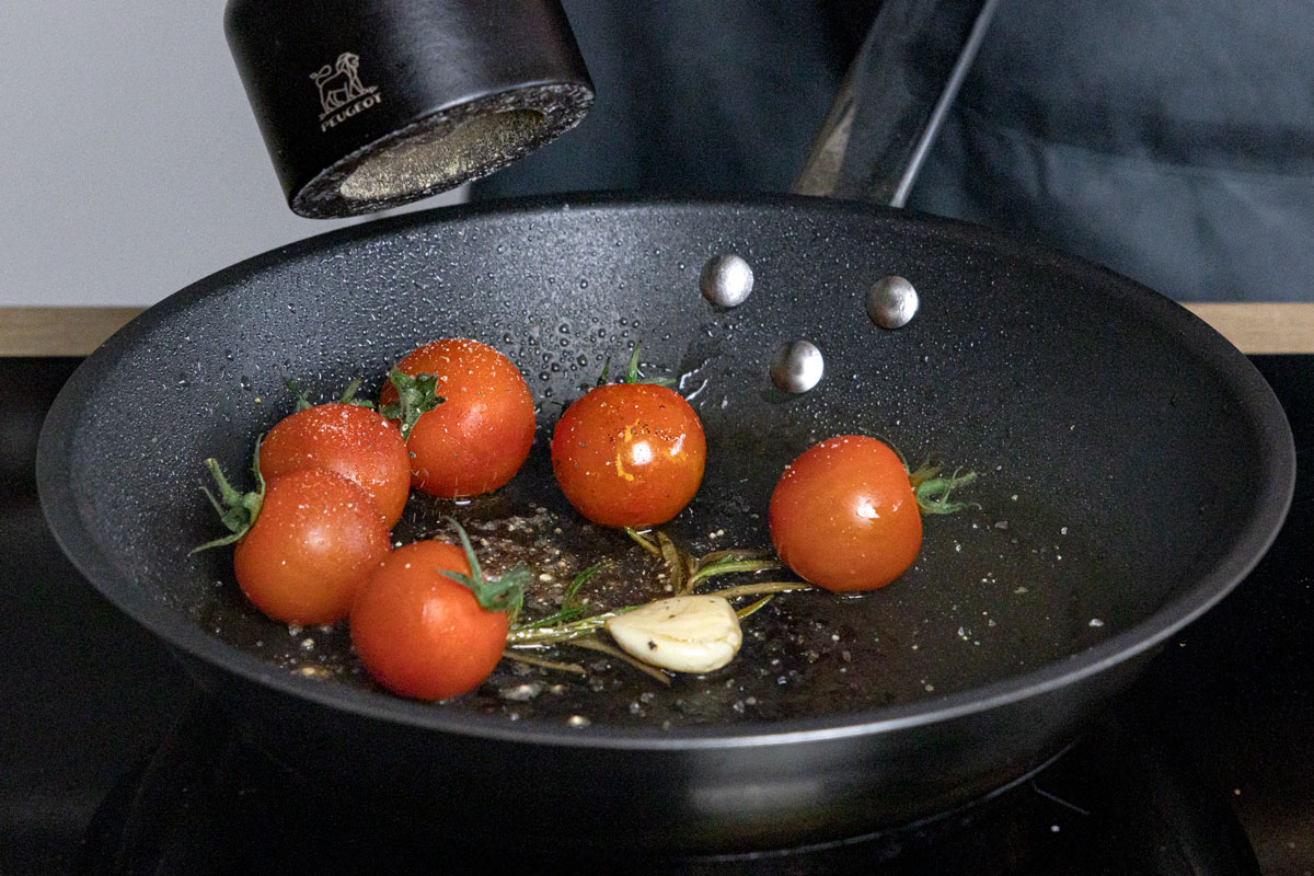 Tomaten, Knoblauch und Kräuter in der Pfanne