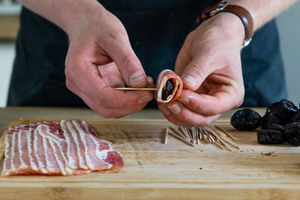 Pflaume im Speckmantel mit Zahnstocher durchspießen