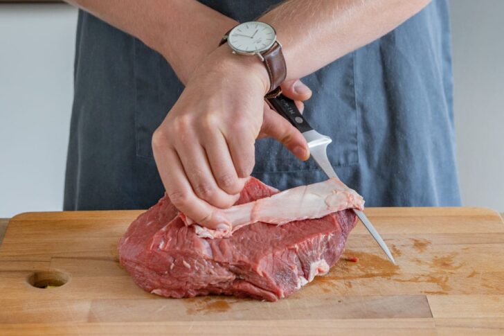 Rinderbraten von Sehnen und Fett befreien