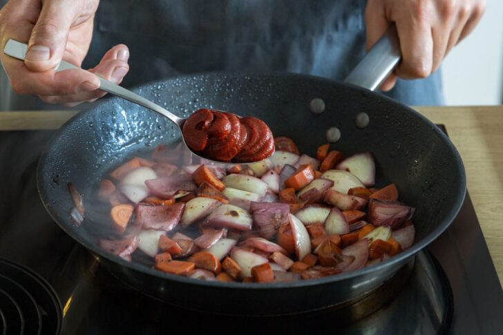 Tomatenmark und Gemüse in Pfanne anschwitzen