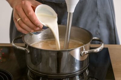 Sahne zur Steckrübensuppe geben