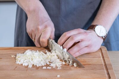 Zwiebeln und Knoblauch in Würfel schneiden
