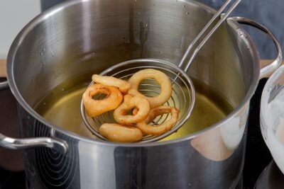 Zwiebelringe aus dem Öl heben