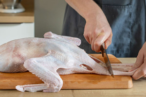 Hals von Entenbraten abschneiden
