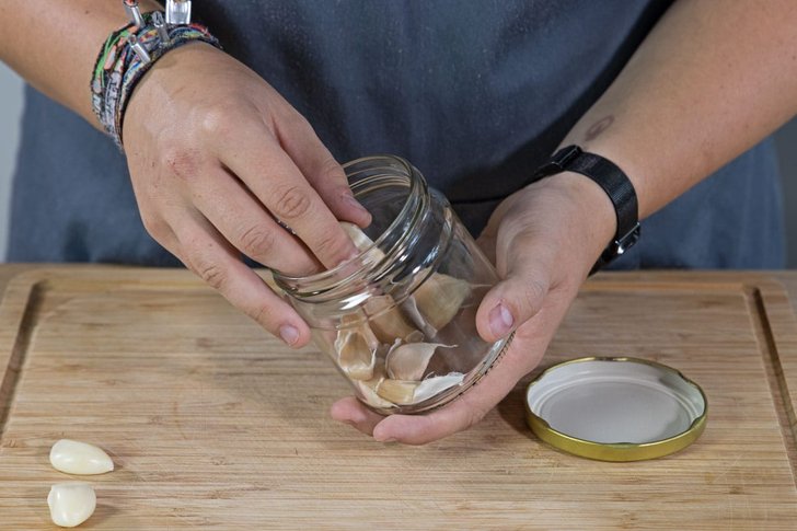 geschälte Knoblauchzehen aus Glas nehmen