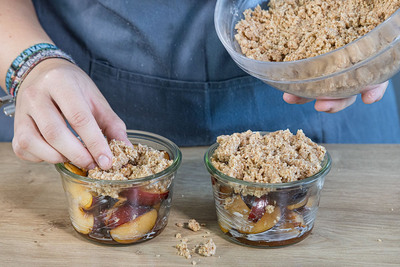 Streusel auf dem Pflaumen verteilen
