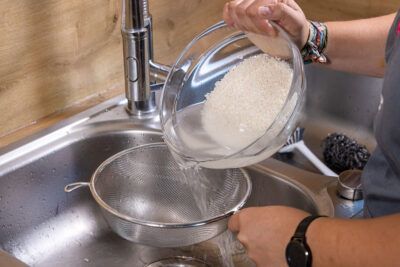 Milchiges Reis-Wasser abgießen