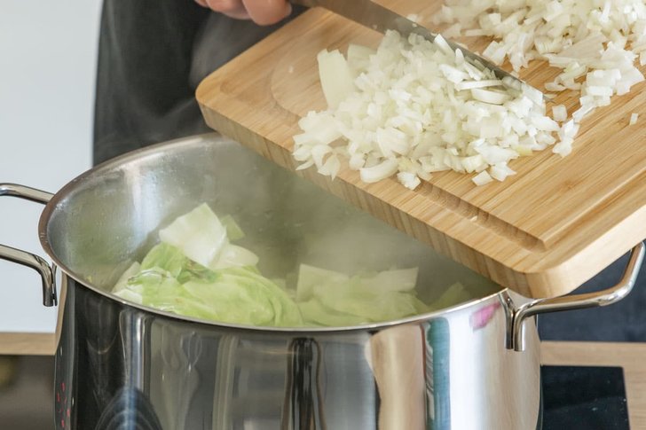 Zwiebel und Knoblauch zum Kohl geben