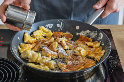 Kaiserschmarrn mit Puderzucker bestreuen