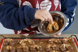 Mandelhörnchen in Schokolade tauchen
