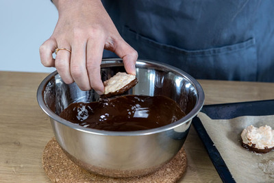 Kokosmakronen in Schokolade tauchen