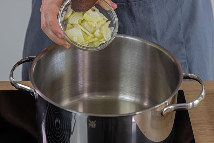 Zwiebeln und Knoblauch in Topf geben