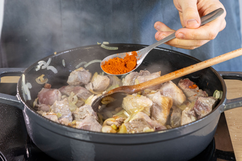 Paprikapulver zum Fleisch geben