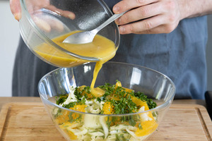 Petersilie und Dressing unter den Salat mischen