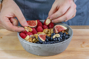 Nüsse und Feigen auf die Frühstücks-Joghurt-Bowl geben