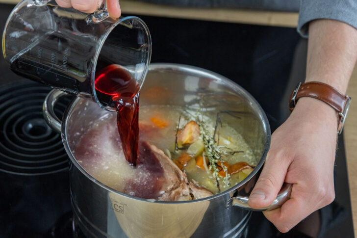 Rotwein zur Gänsekarkasse und Bratenfüllung gießen
