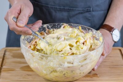 Mayonnaise unter Omas Kartoffelsalat rühren