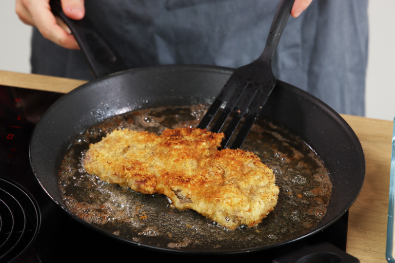 Paniertes Kalbsschnitzel in Pfanne braten