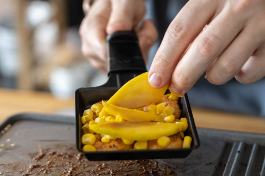 Mango und Mais in das Raclette Pfännchen dazugeben