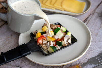 Sahne zum Hähnchen Raclette Pfännchen gießen