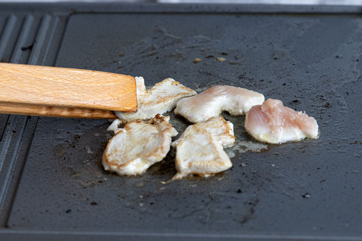 Hähnchen auf der Grillplatte des Raclettes anbraten
