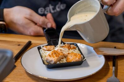 Sahne zum Lachs Raclette gießen