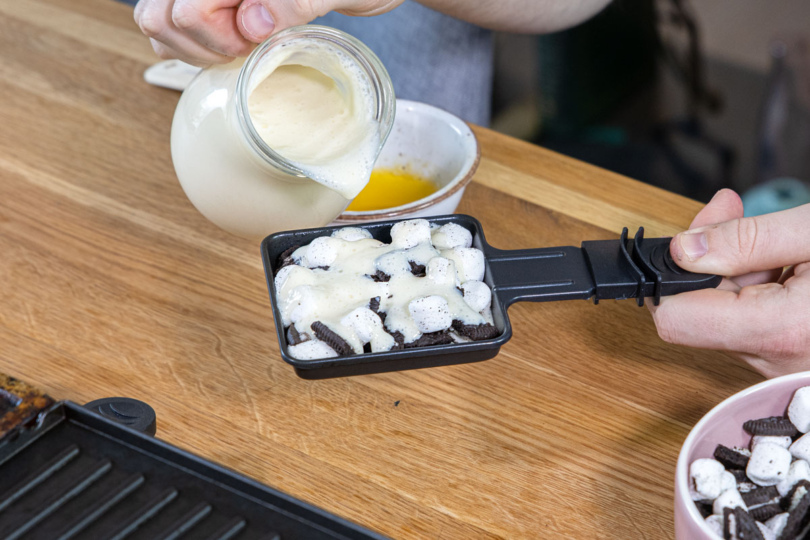 Vanillesauce über süßes Raclette mit Oreo Marshmallow Pfännchen geben